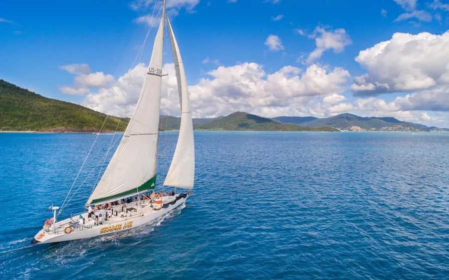 一艘帆船满帆航行在 Whitsundays 的碧蓝海面上